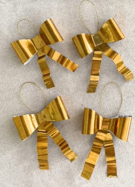 Brass bow Christmas decorations upcycled from empty tomato puree tubes.