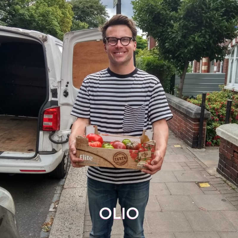 Person holding a box of tomatoes shared via the OLIO food waste app