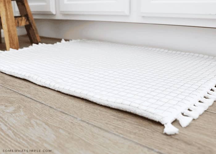 White bath mat made from a towel.