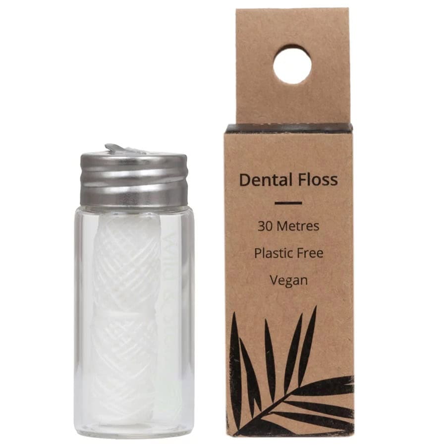 Glass jar of dental floss, next to a cardboard box that reads dental floss, 30 metres, plastic-free, vegan.