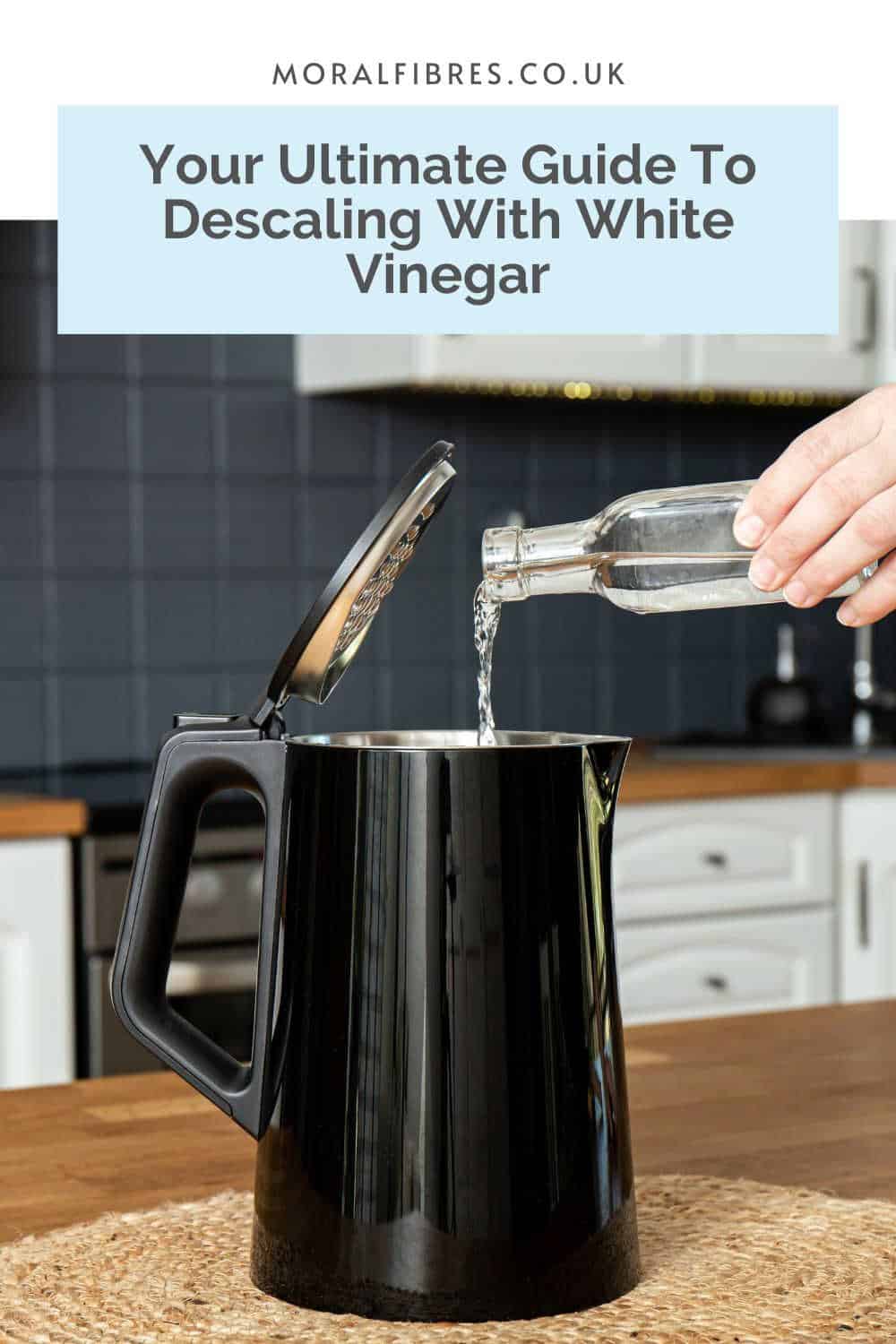 Person pouring a glass bottle of vinegar into a black kettle, with a blue text box that reads your ultimate guide to descaling with white vinegar.