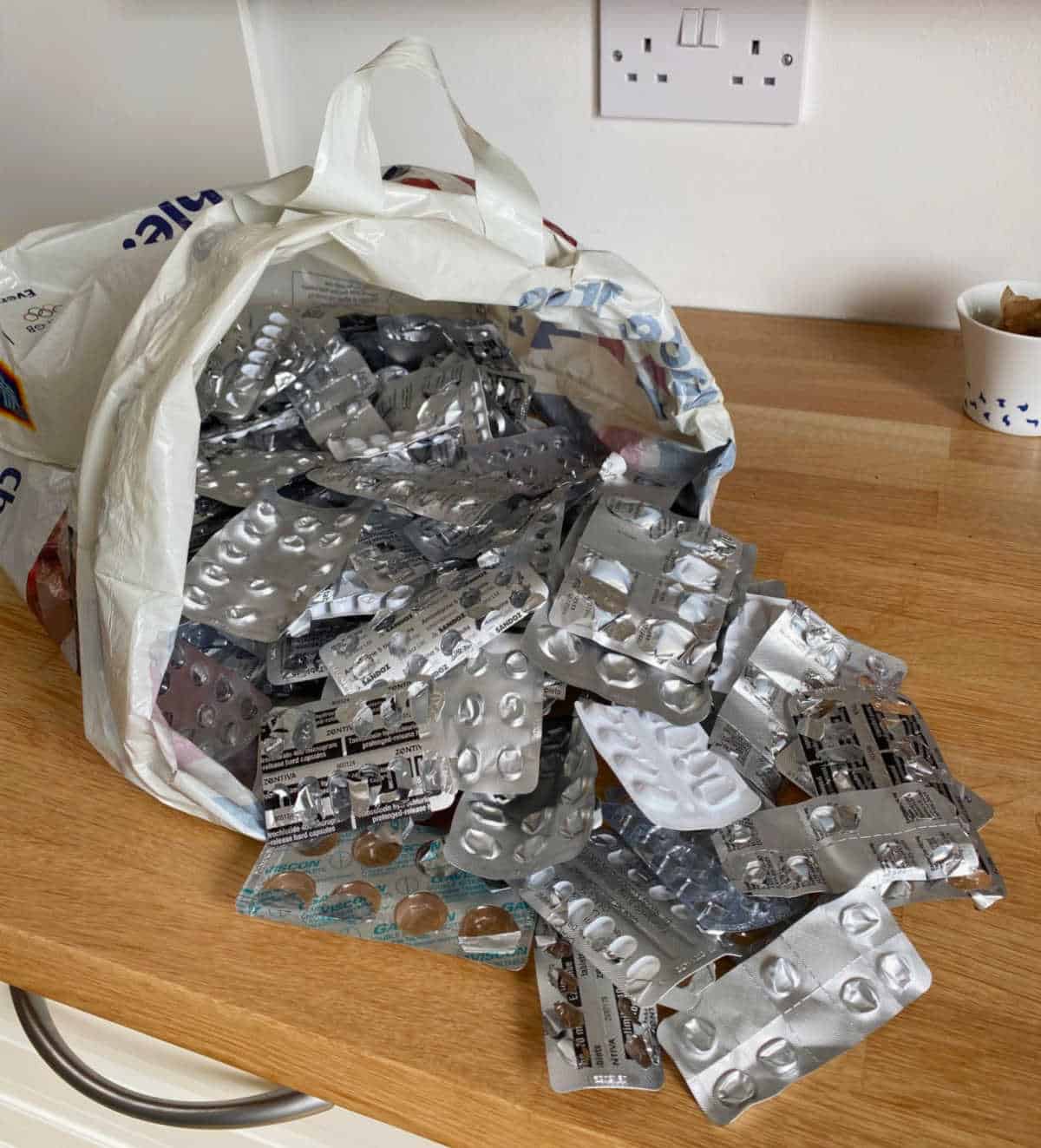 Plastic bag overflowing with medicine packaging.